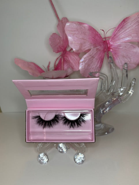 Lunaria celestial lashes displayed with pink accents in a stylish holder, showcasing luxury real mink for an ethereal look.